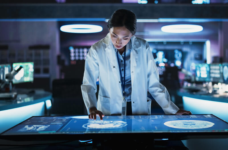 Neuroscientist using touch screen table with MRI scans