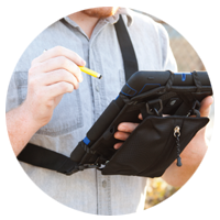 Hands typing on laptop with hard hat setting on the desk also.