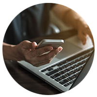 Hands using laptop and mobile device