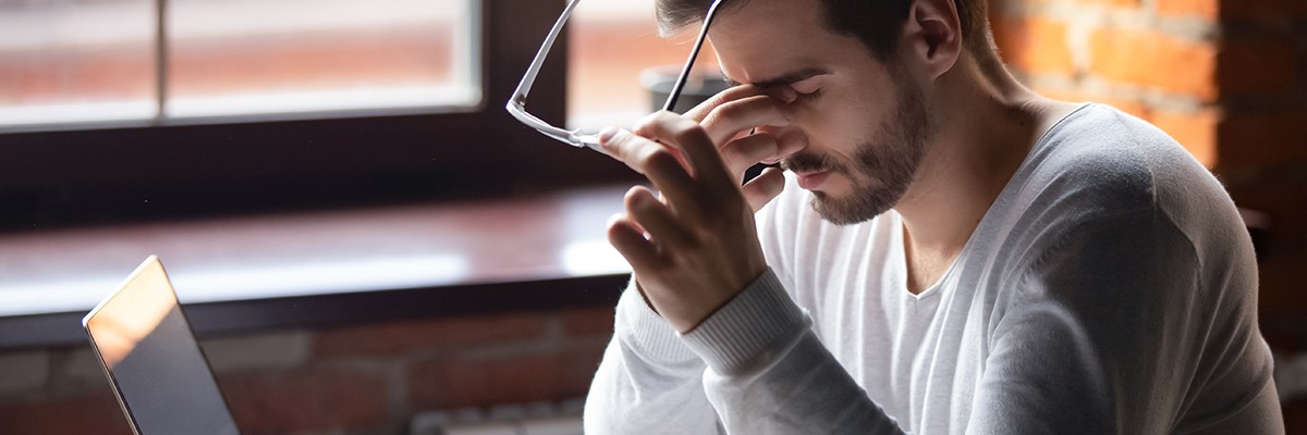 Man in stressed while working on computer.