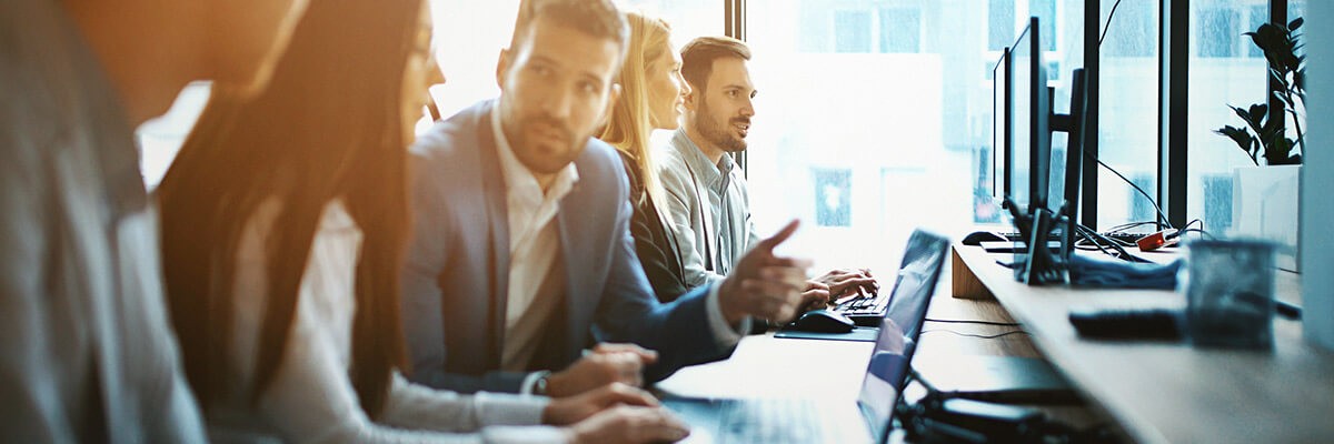 Business professionals using laptops in a modern office meeting