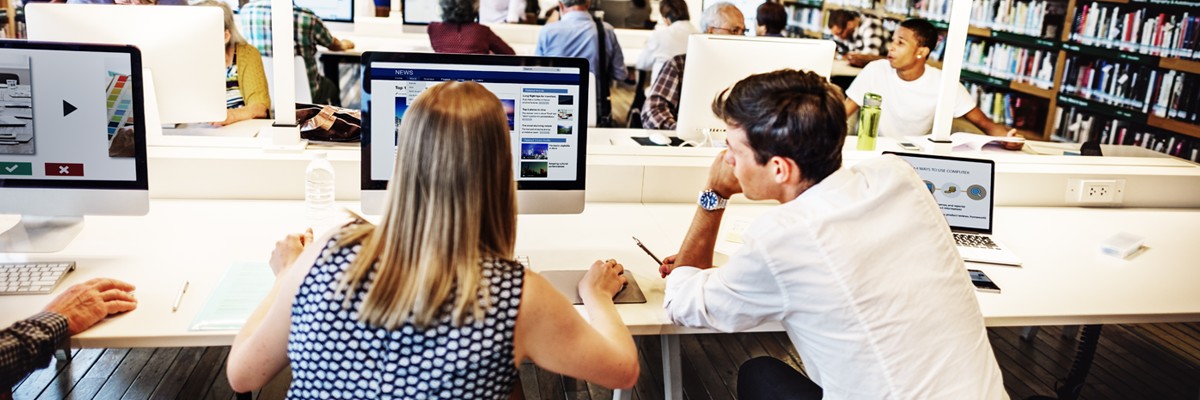 Close up of college students collaborating in computer lab library area