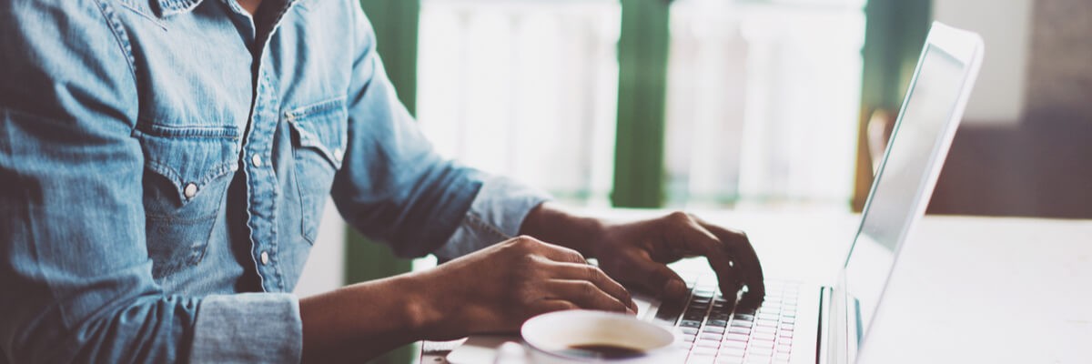 Close up of businessman typing on laptop keyboard