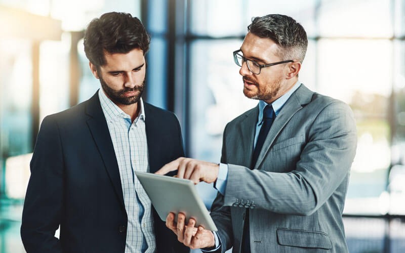Two business men looking over tablet device