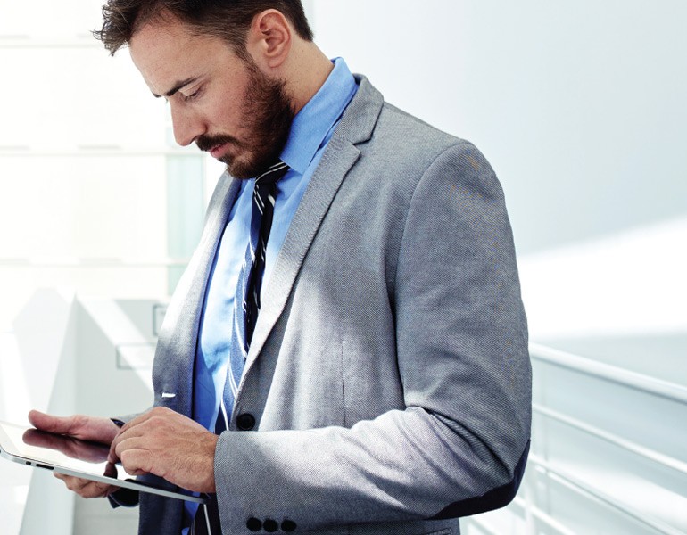 Business executive using tablet computer away from desk