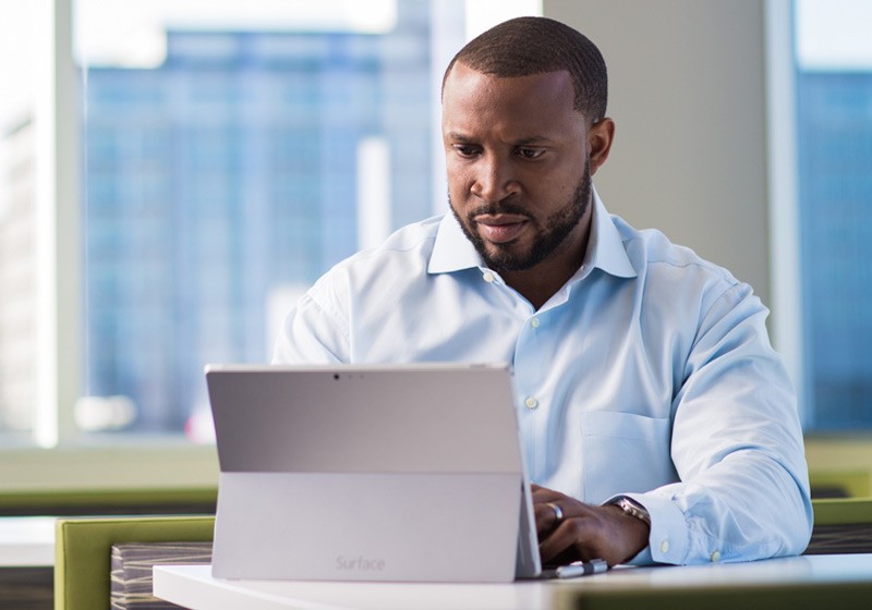 Business manager reviewing applications off of his Surface Pro mobile tablet device