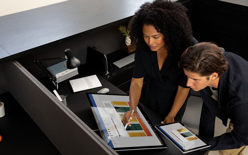 Surface Studio 2 features the Windows 10 Pro operating system Male and female using Surface Studio 2