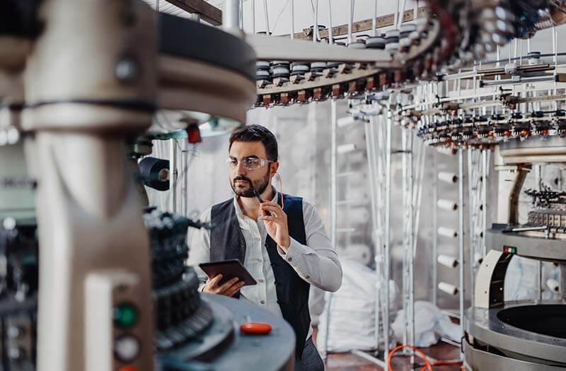 Employee checking manufacturing production with mobile device