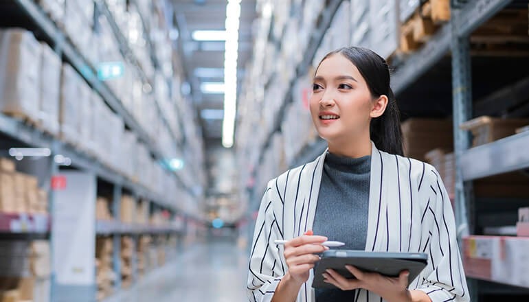 Businesswoman with tablet in warehouse